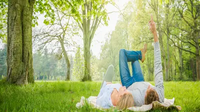 Homme et femme allongés dans une prairie, regardant vers le ciel