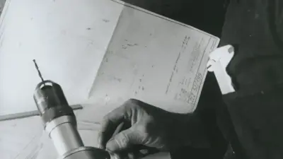 L'image montre un ancien plan de bâtiment réalisé par Bosch, des outils et une perceuse.